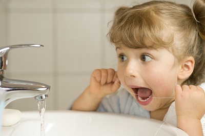 young girl flossing