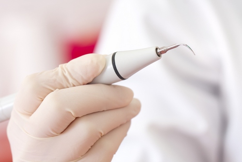 Doctor holds ultrasnoic scalers in hands